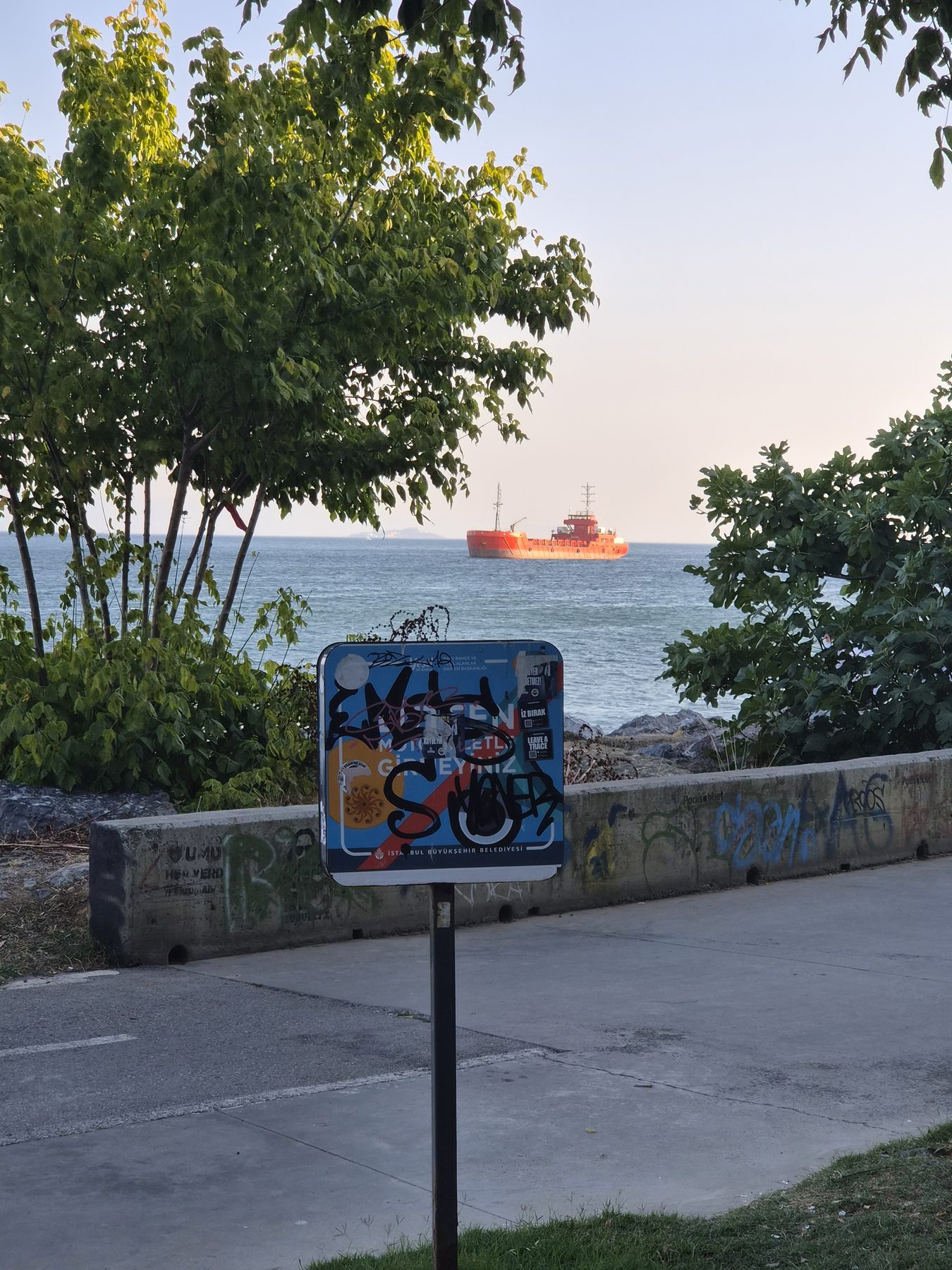 A working sea, a defaced sign.